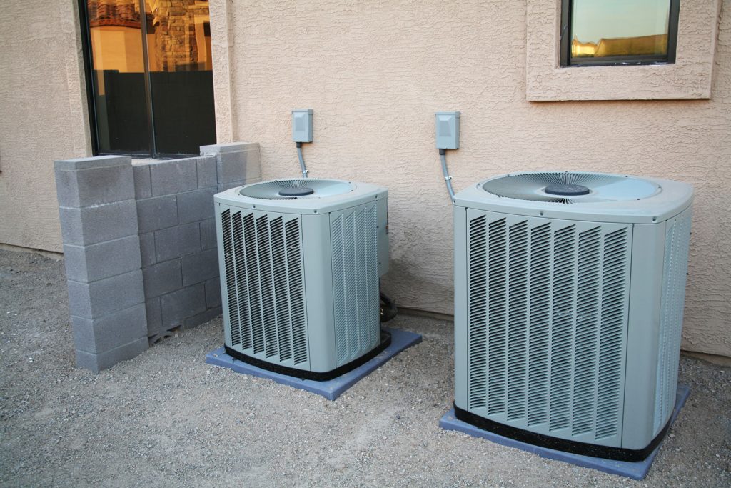 Two air conditioning pair condensers installed outside a luxurious house