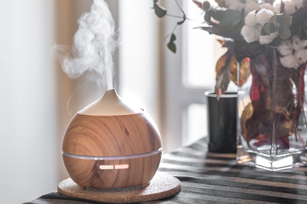 Wooden covered humidifier on the table with a gorgeous vase on the side
