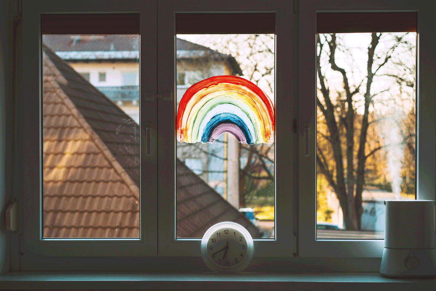 painting rainbow on window. Rainbow painted with paints on glass
