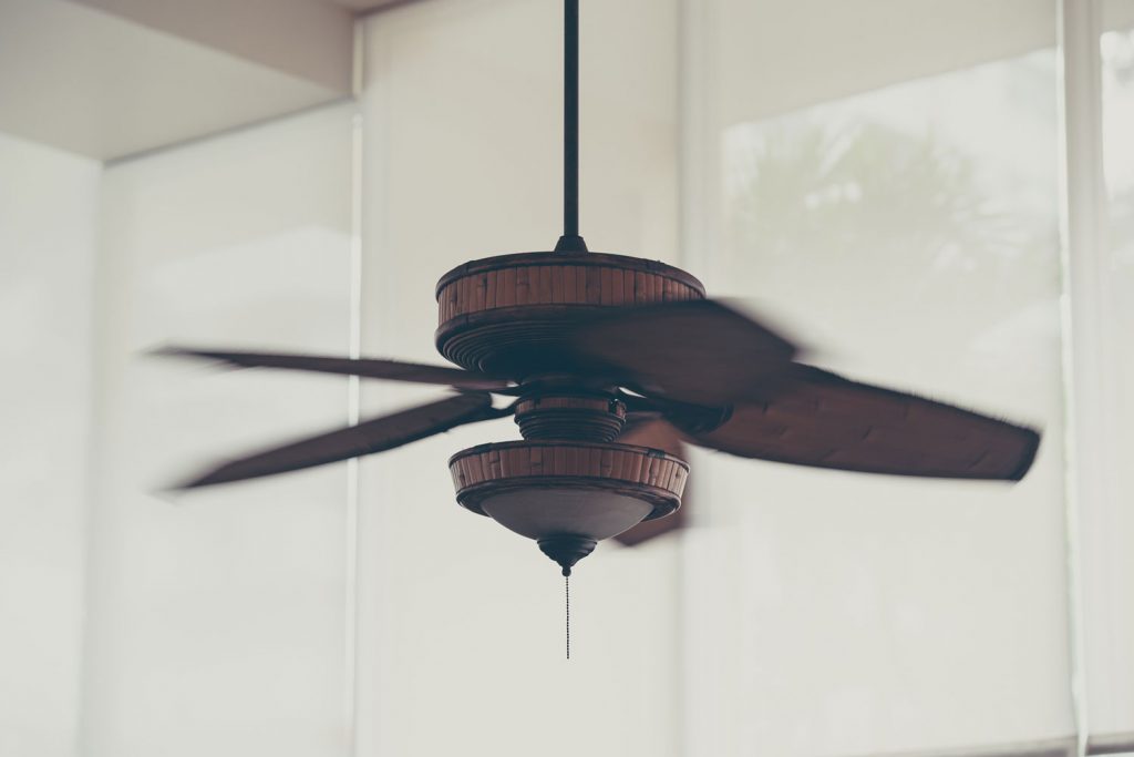 A brown ceiling fan photographed at high speed