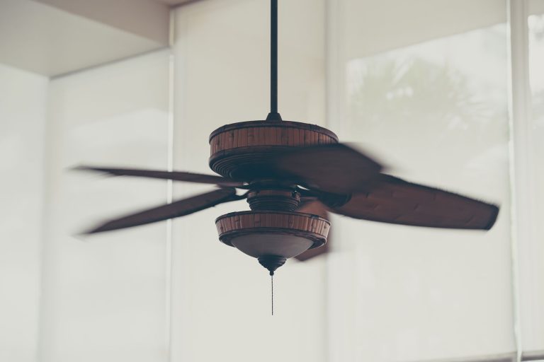 A brown ceiling fan photographed at high speed, Can You Replace Ceiling Fan Blades With Longer Ones? [And How To]