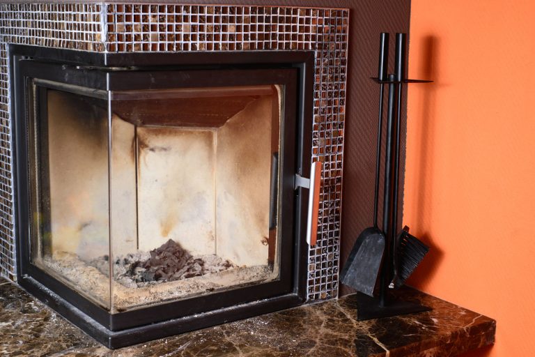 A glass wall fireplace with decorative mantel, Can You Vacuum Fireplace Ashes?