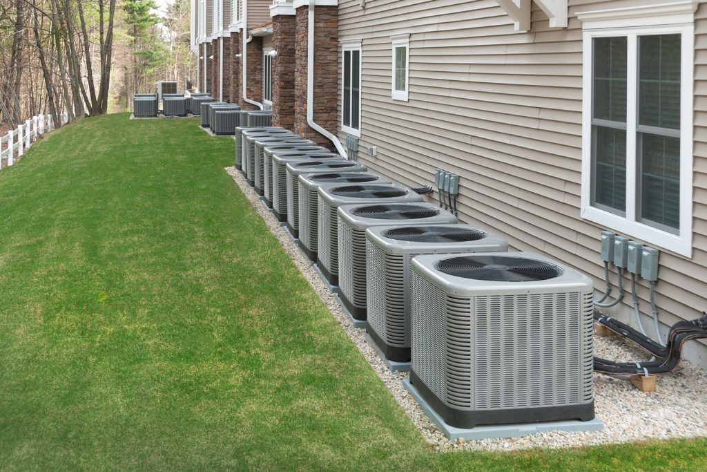A line of heat pump units at the back of the house