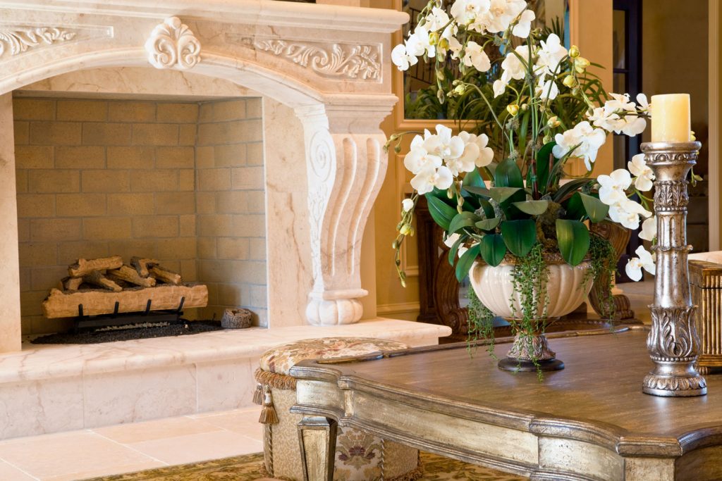 A luxurious fireplace with a mid century design and flowers on the table