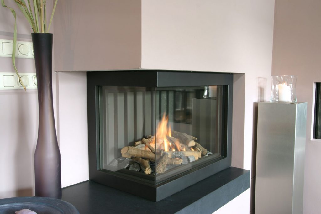 A modern contemporary designed fireplace with wood burning inside