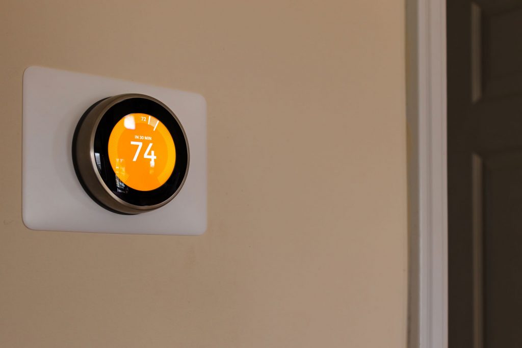 A smart thermostat installed on the side do the wall set at 47 degrees Fahrenheit