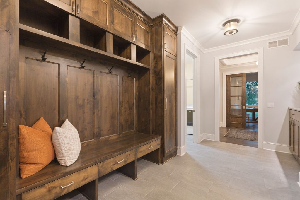 A spacious mudroom with a wooden cabinet incorporated with a wooden nook and cabinets