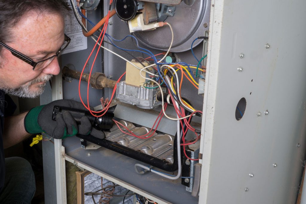 A technician repairing the propane furnace