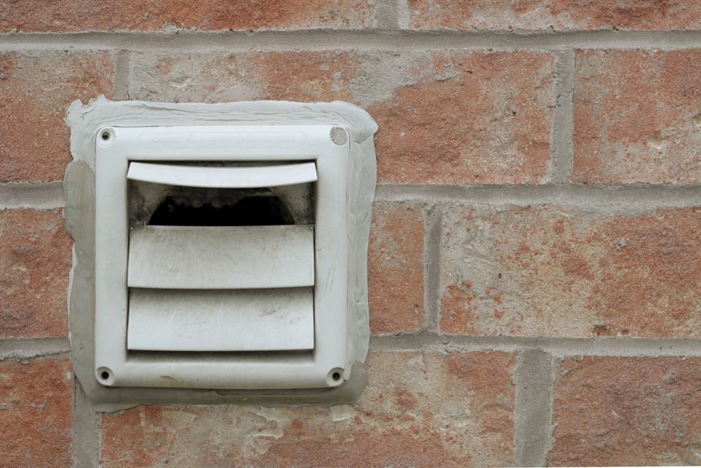 A vent outside a brick house