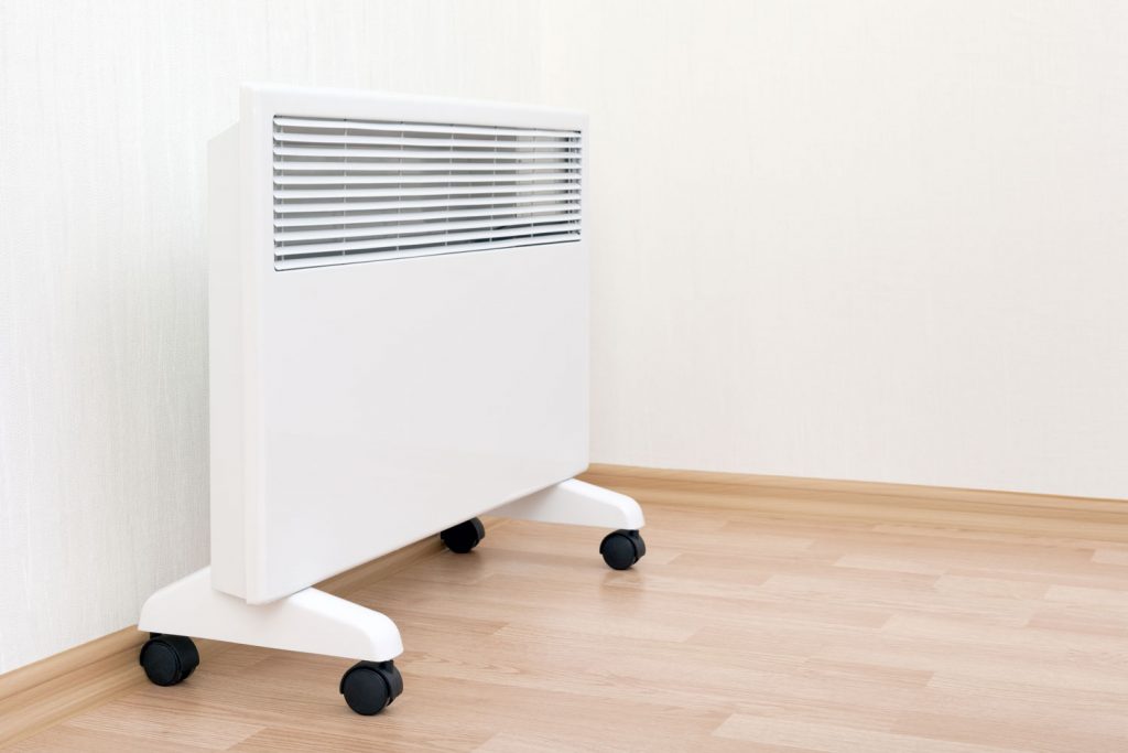 A white heater with wheels inside the living room
