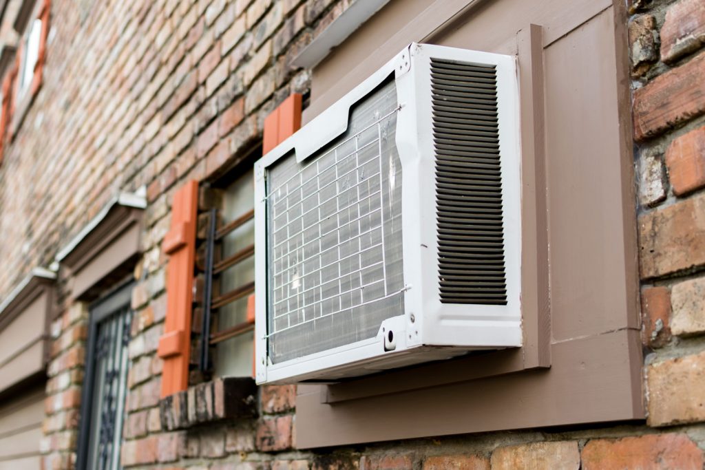 A window air conditioner of a huge brick building