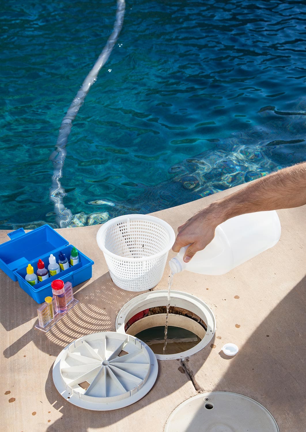 Adding chemicals to pool with testing kit