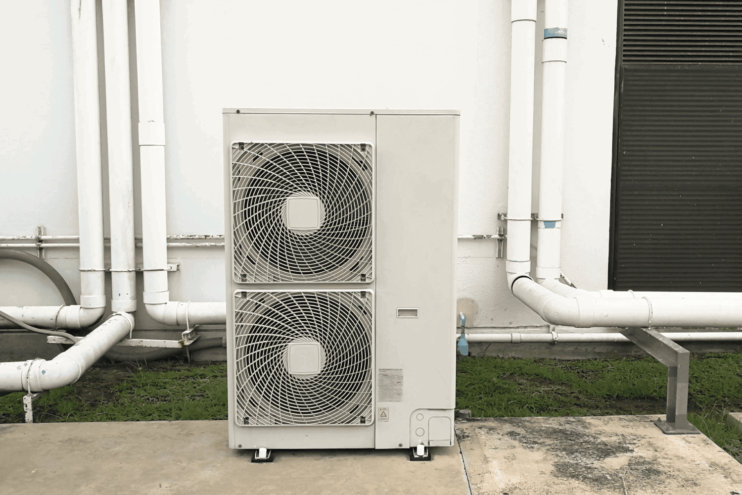 Air conditioning out door,A group of three industrial sized air conditioners along a brick wall