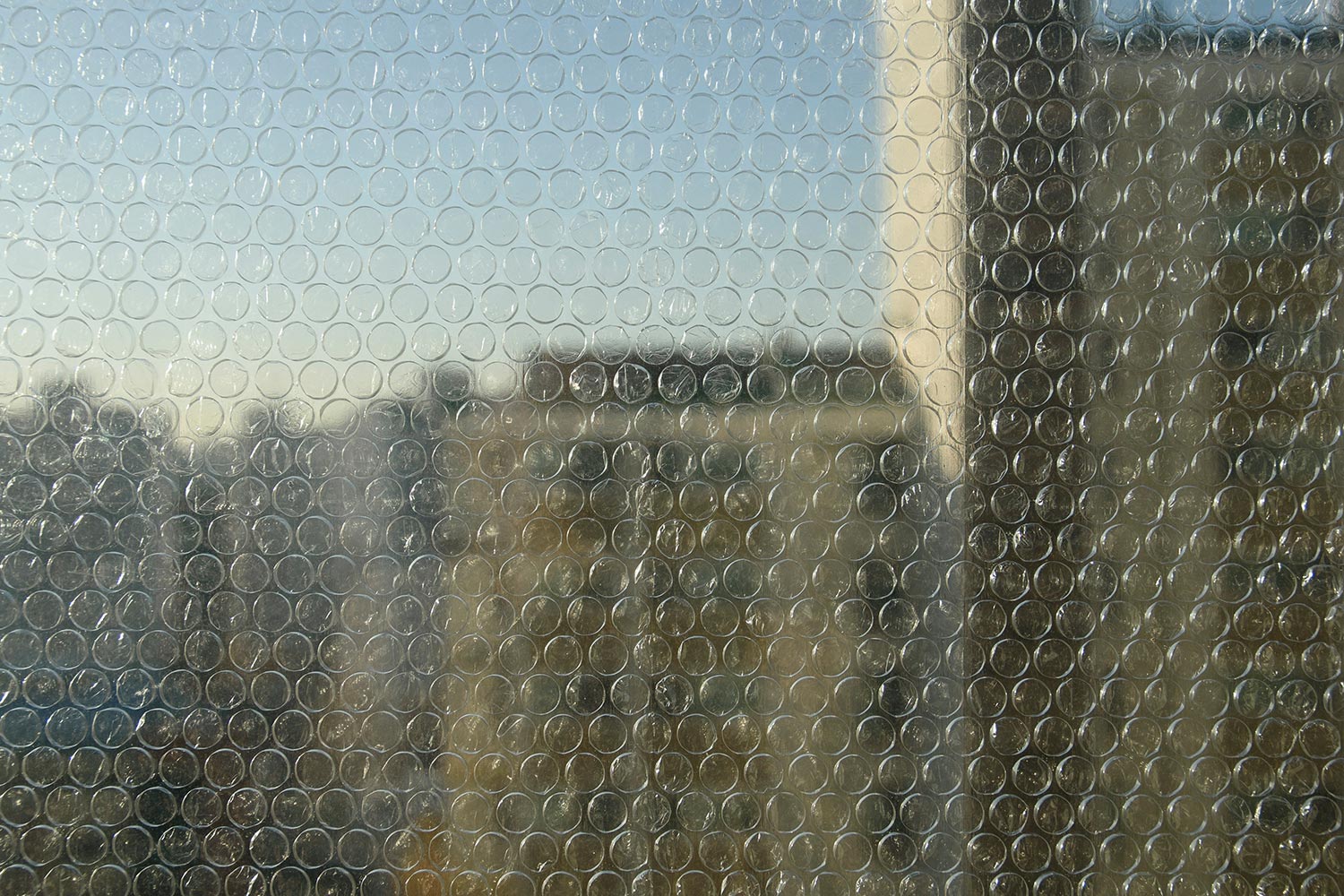 Bubble wrap packaging attached to windows together as insulation for winter