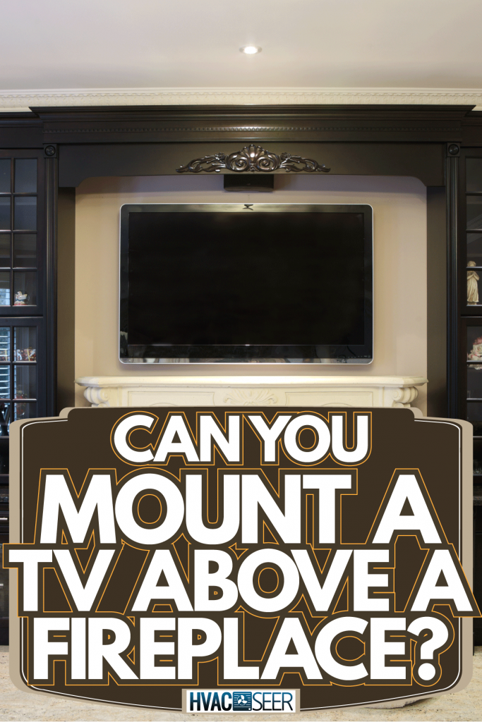 A gorgeous entertainment are with black cabinets and white mantel fireplace with a TV on top, Can You Mount A TV Above A Fireplace?