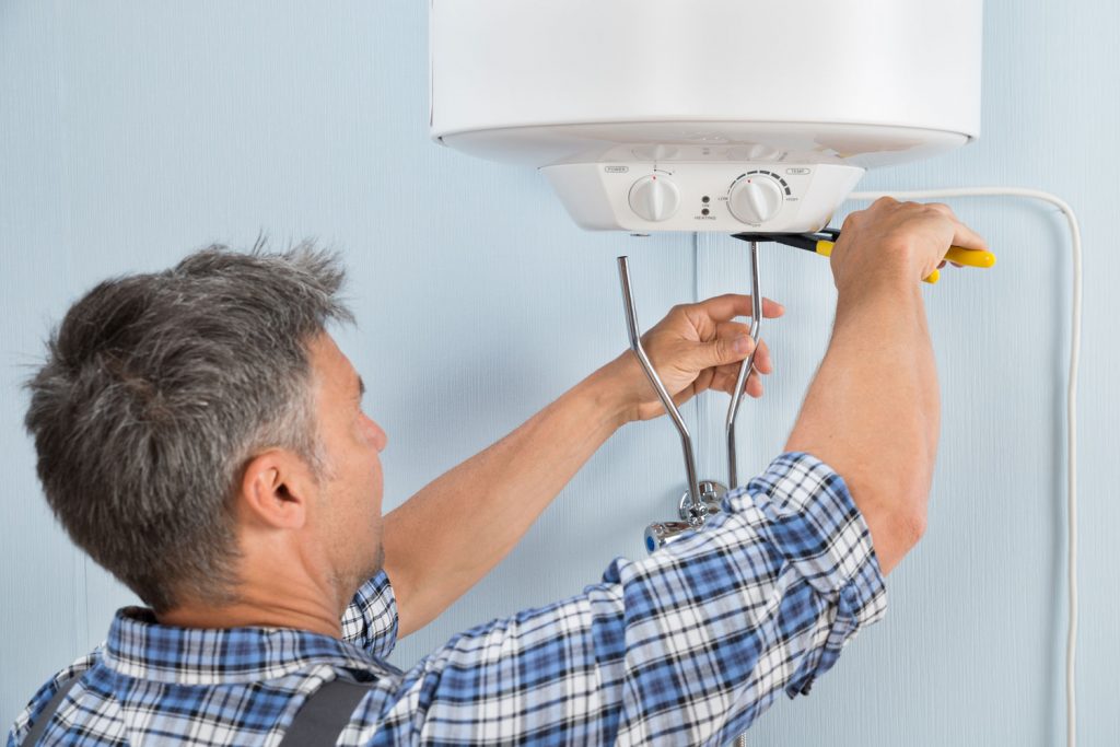 Close-up Of Mid-adult Male Plumber Installing Water Heater