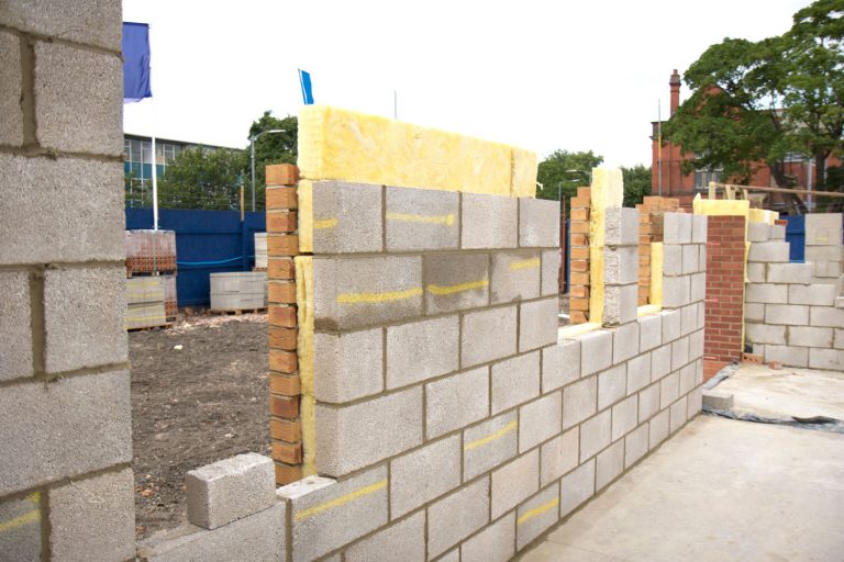 Cross Section Of A Newly Built Wall of a construction site - layers of breeze block ,brick, and thermal insulation, R-Value Of A Cinder Block Wall