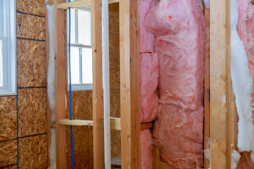 Fiberglass insulation on the wooden framing of a house undergoing construction
