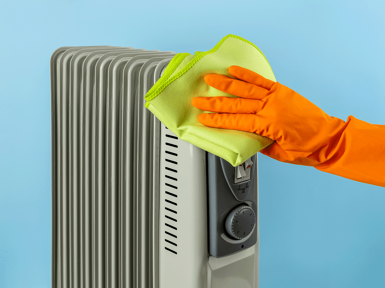 Hand wiping microfiber cloth on electric heater