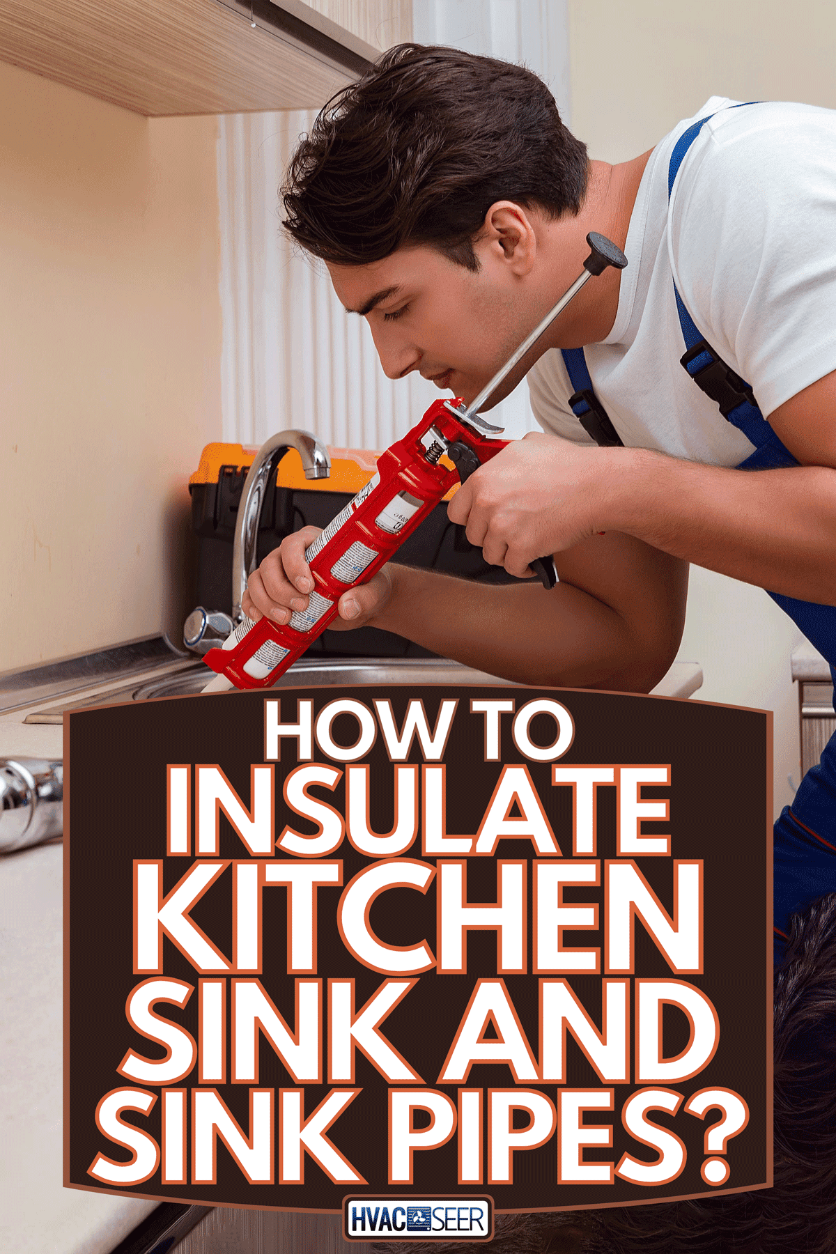 A young repairman working at the kitchen, How To Insulate Kitchen Sink And Sink Pipes?