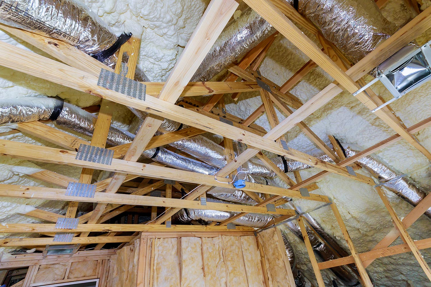 Installing attic insulation material is sprayed with liquid foam of heating system air condition system on the roof