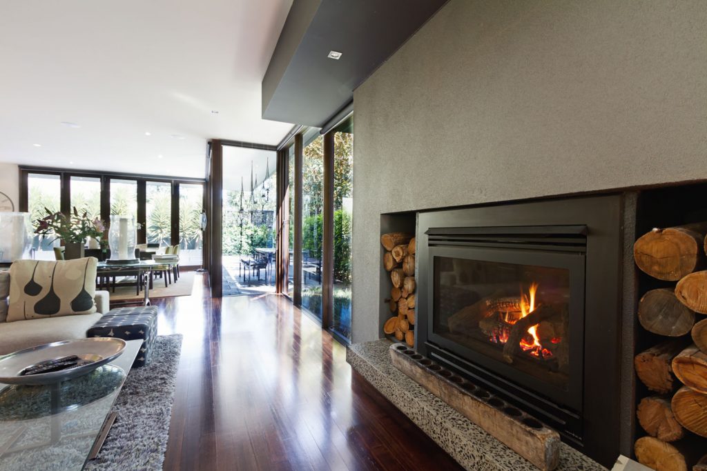 Luxurious interior mansion with a gas log fireplace, wooden flooring and white stucco roofing
