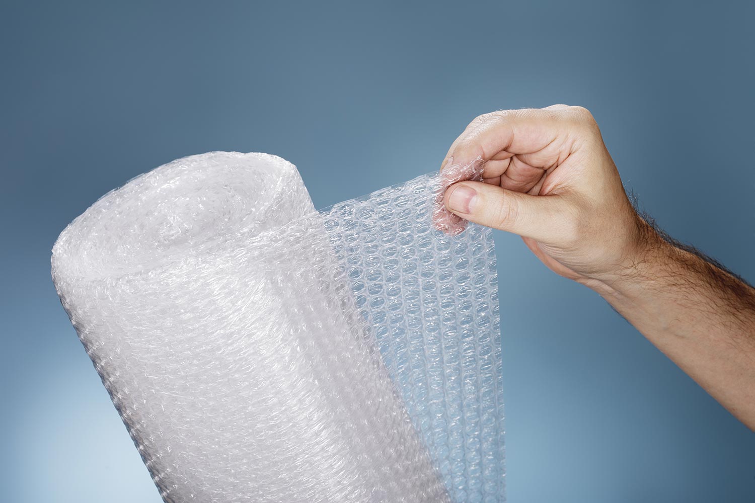 Man holding a roll of plastic bubble wrap