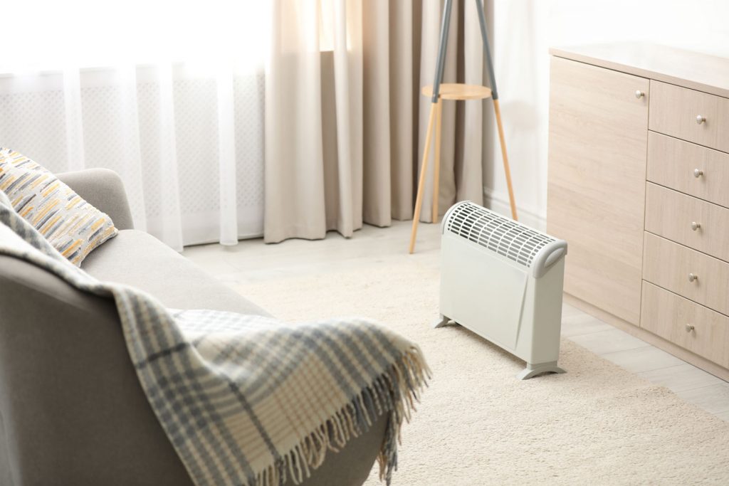 Modern electric heater in stylish room interior
