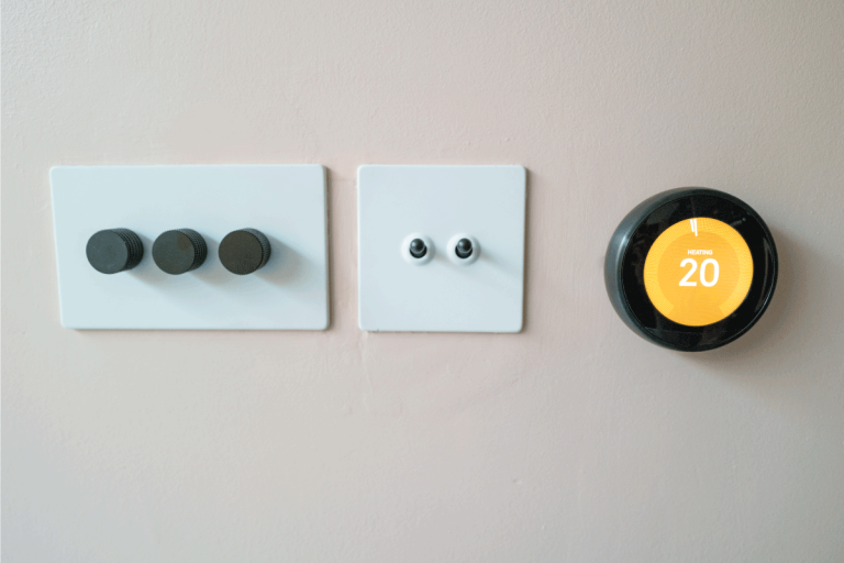 Modern wireless smart thermostat installed on the wall at home. How Long Should You Charge A Nest Thermostat