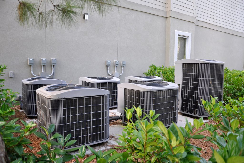 Small and huge air conditioning units outside a house