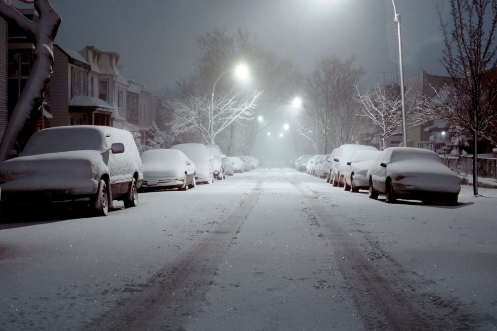 Snow-Covered Cars Lit by Street Lights