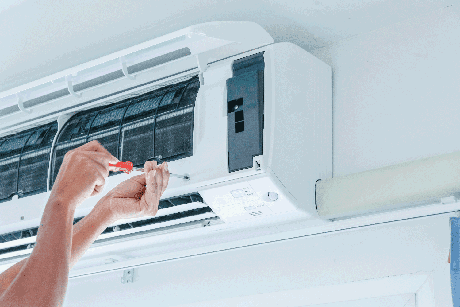 The technician repairing the air conditioner by use screwdriver