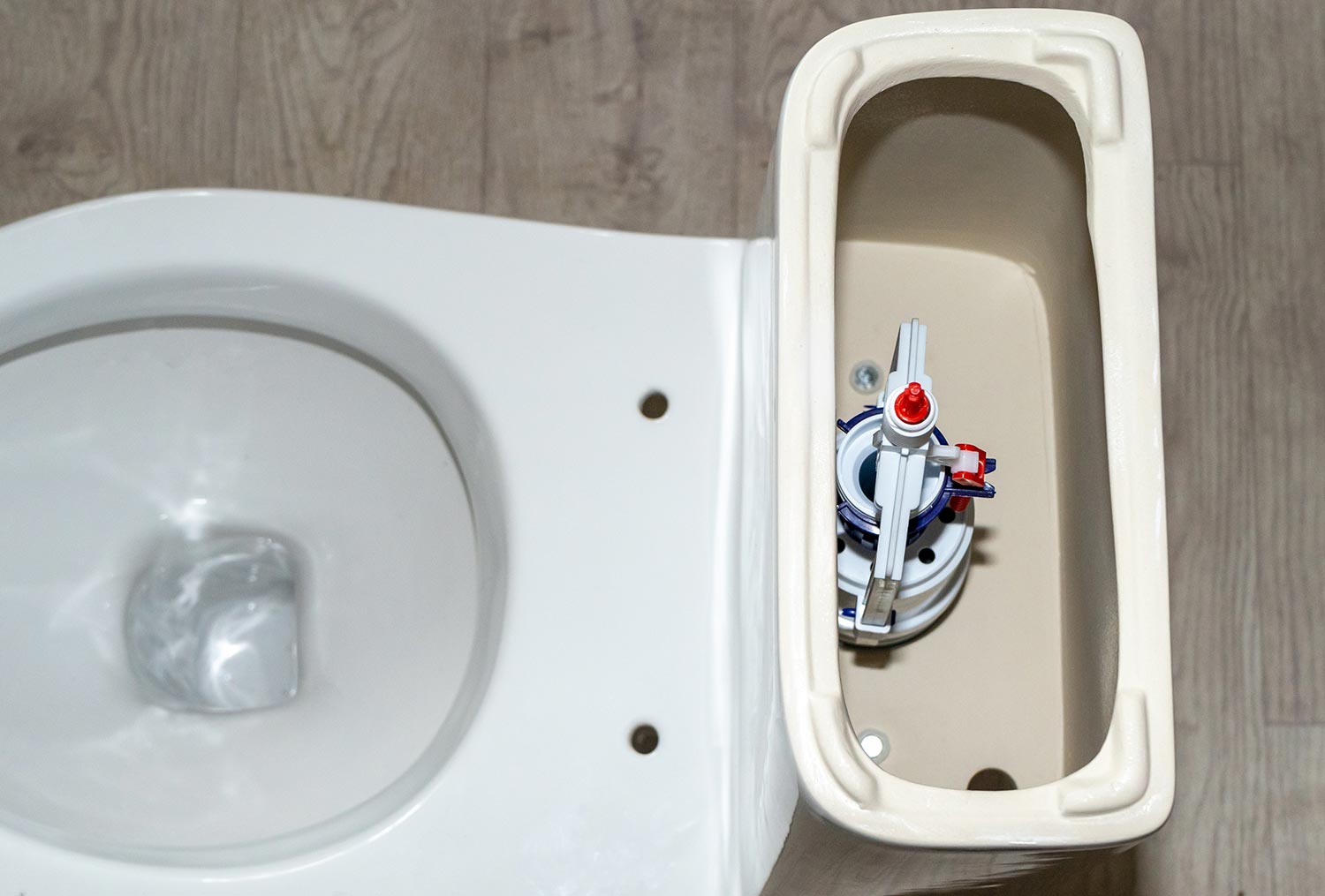 White toilet tank with an open lid and flush system