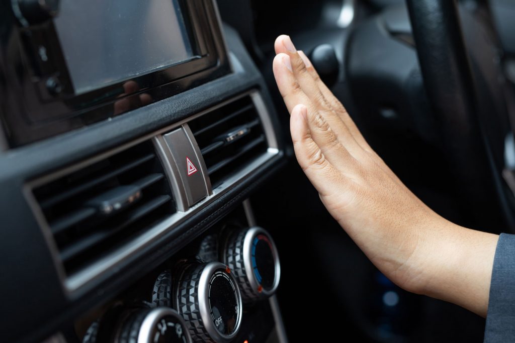 Womans hands feeling the air conditioning in the car