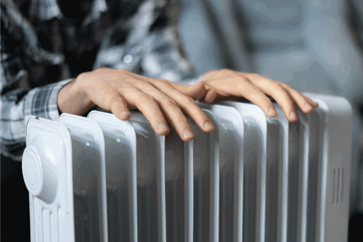 feeling cold, getting warm, hands touching the heater close up. Electric Heater Turns On And Off Repeatedly—Is Something Wrong