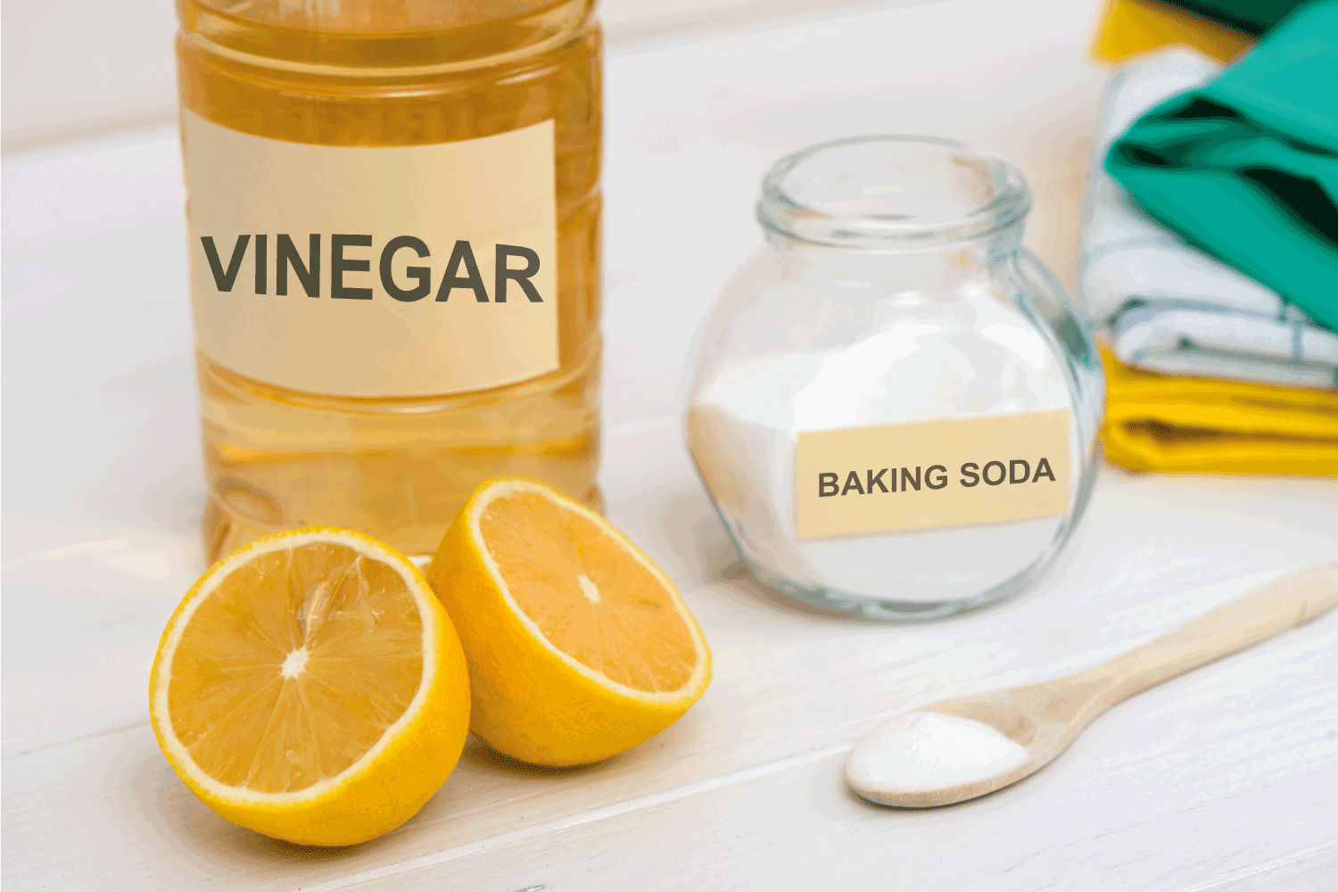 natural cleaners, baking soda, vinegar, and lemons on a table