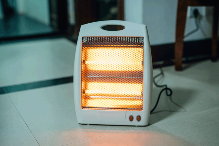 portable-electric-heater-turned-on-at-the-floor-of-an-american-home.-Heater-Or-AC-Which-Uses-More-Electricity