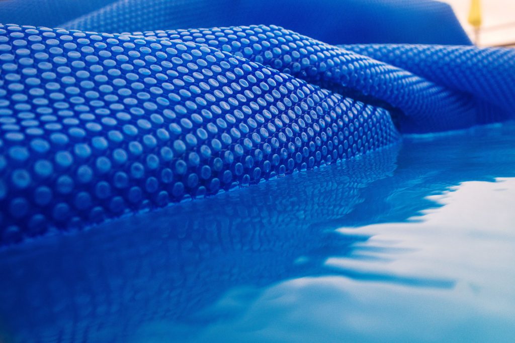 texture of the blue solar film for the swimming pool on the water