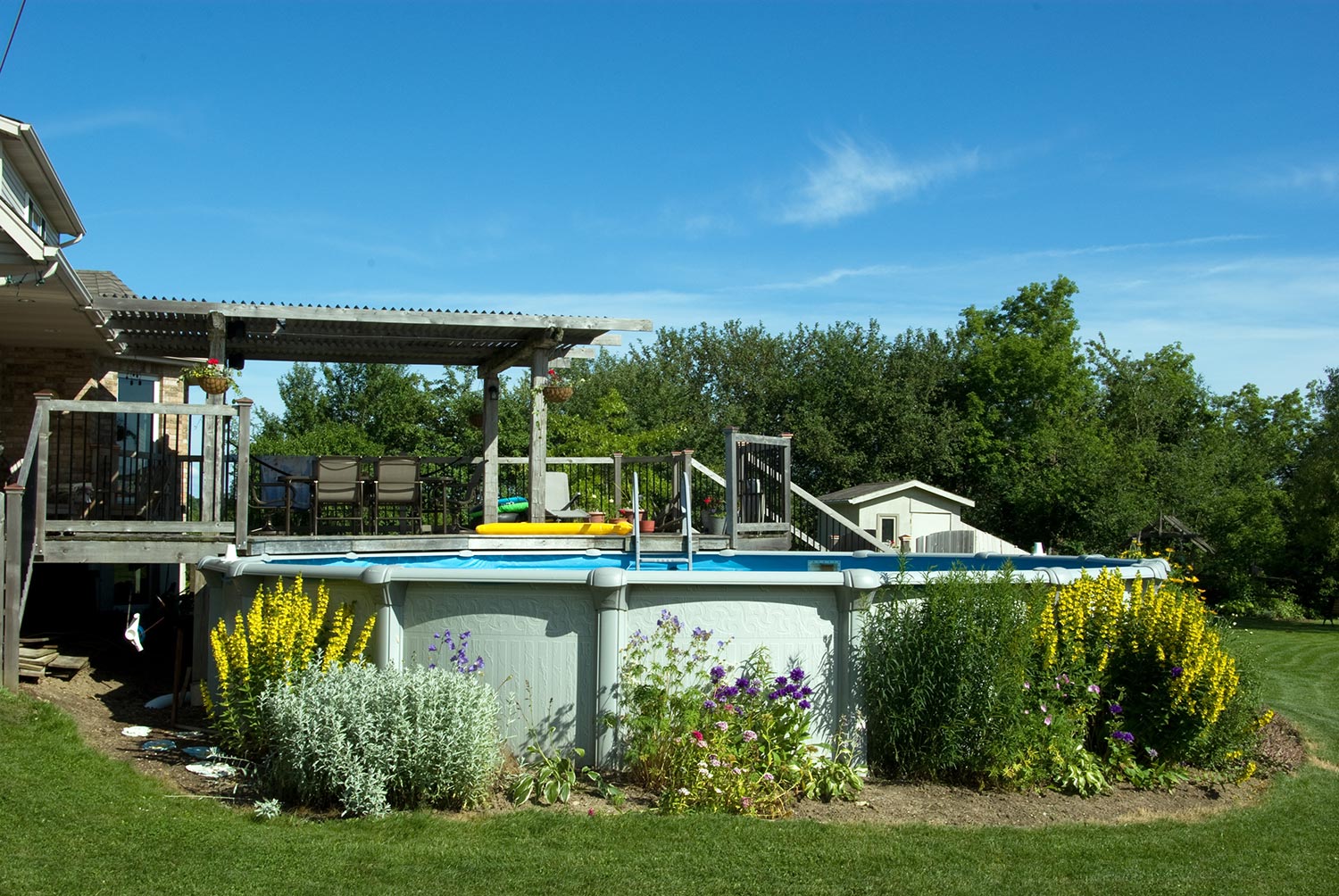 A backyard deck and above ground swimming pool