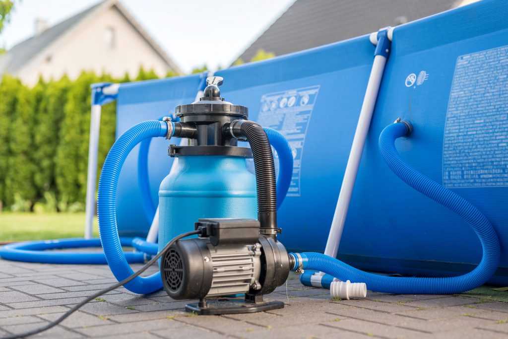 A blue sand pool filter being used for cleaning an above ground pool water