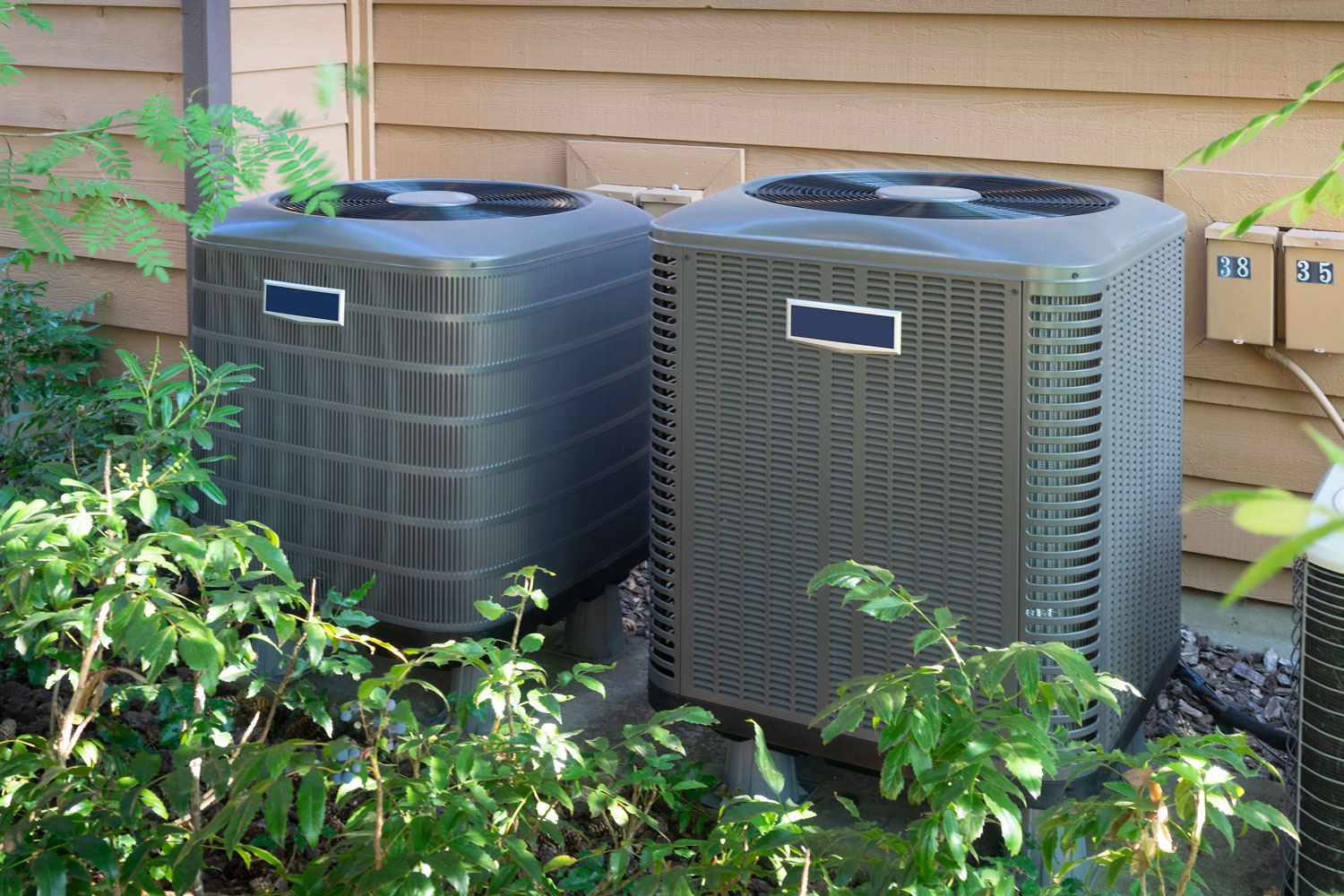 A gray color air conditioning units outside a house