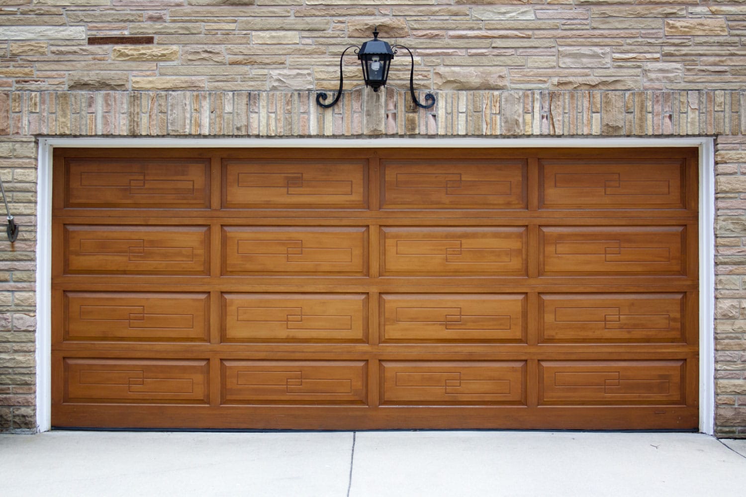 A huge wooden garage door with white trims