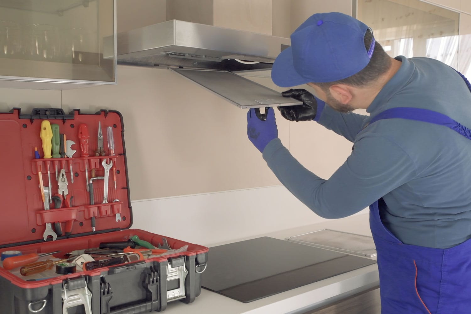 A specialist installing a kitchen range hood