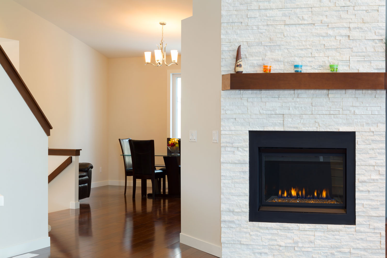 A white mantel fireplace inside a luxurious living room with wooden flooring and beige painted walls