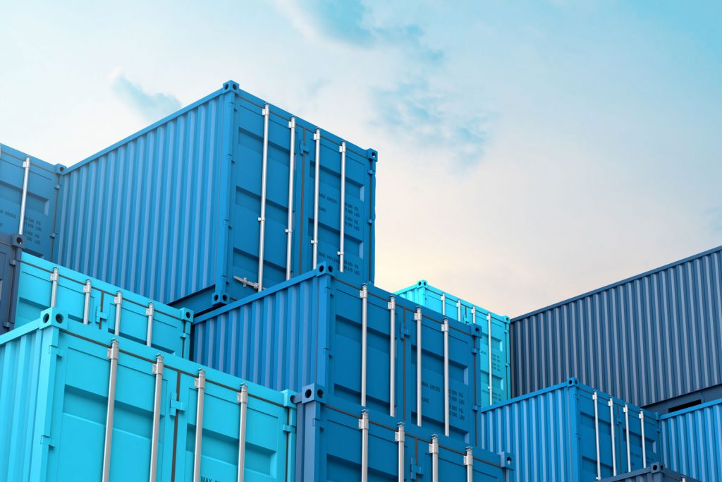 Blue colored shipping containers stockpiled at a dock