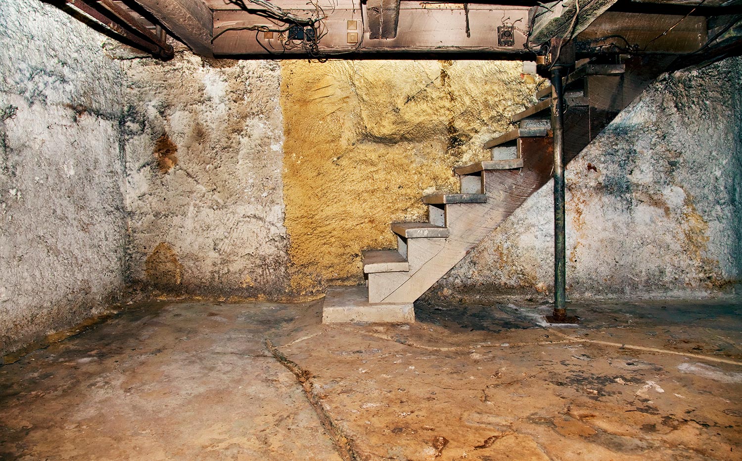 Decrepit basement featuring a soot-covered stairway