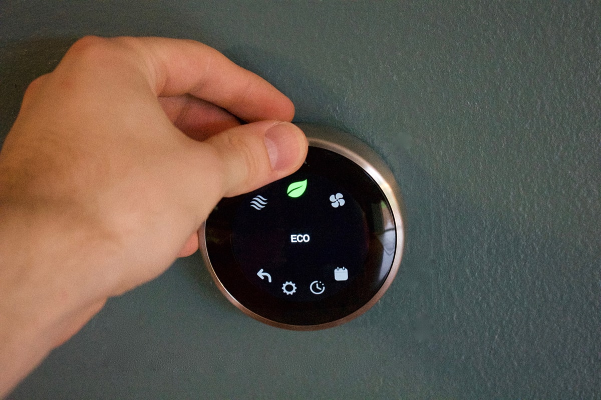 Hand adjusting thermostats on eco mode