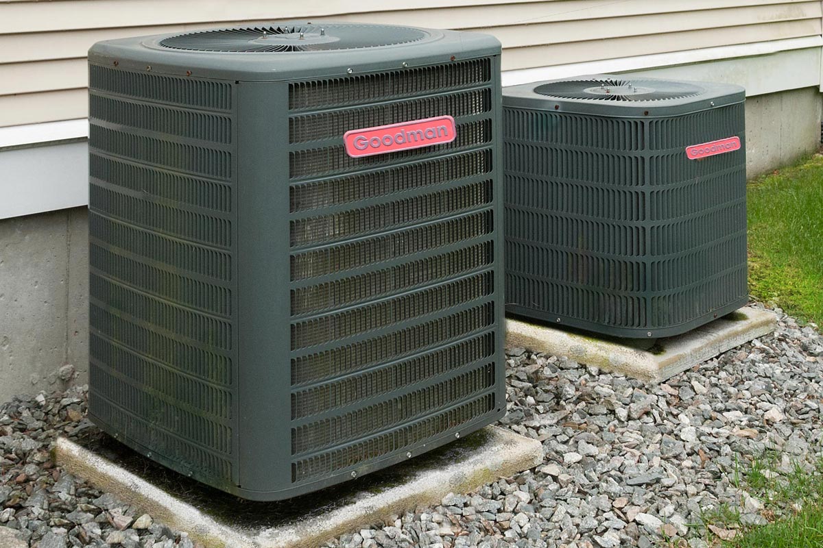 A heating and air conditioning units in back of an apartment complex