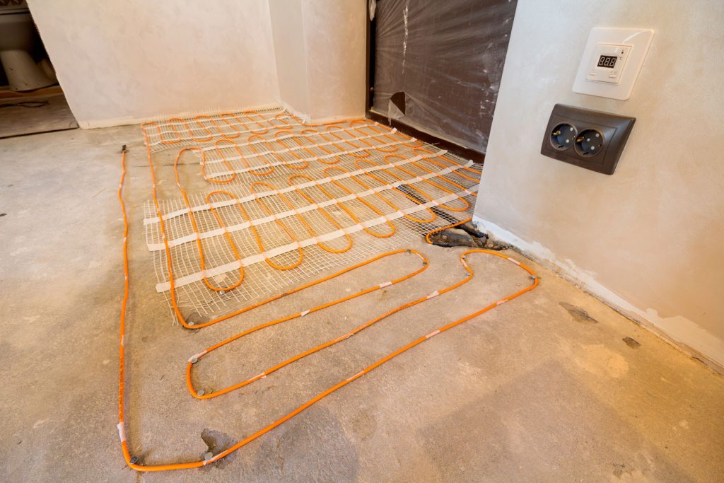 Heating red electrical cable wire system installed on cement floor