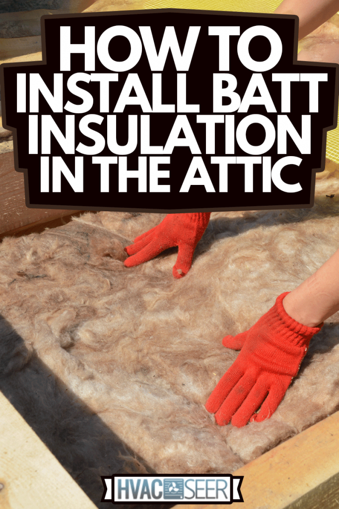 Constructing a rooftop a building contractor in protective gloves is lying glass wool batt insulation between the roofbeams for energy efficiency of the house attic insulation, How To Install Batt Insulation In The Attic